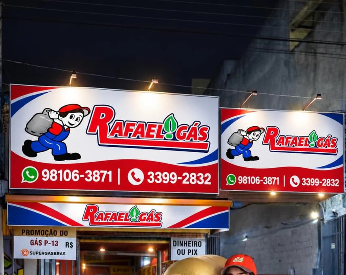 Fachada iluminada do Rafael Gás à noite, com as placas da loja acesas